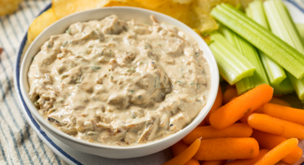 A bowl of gluten-free onion soup dip with carrots and celery